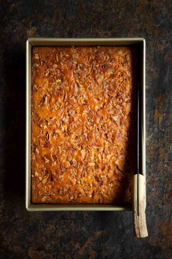 A large rectangular pan with bacon cornbread in it and a large knife.