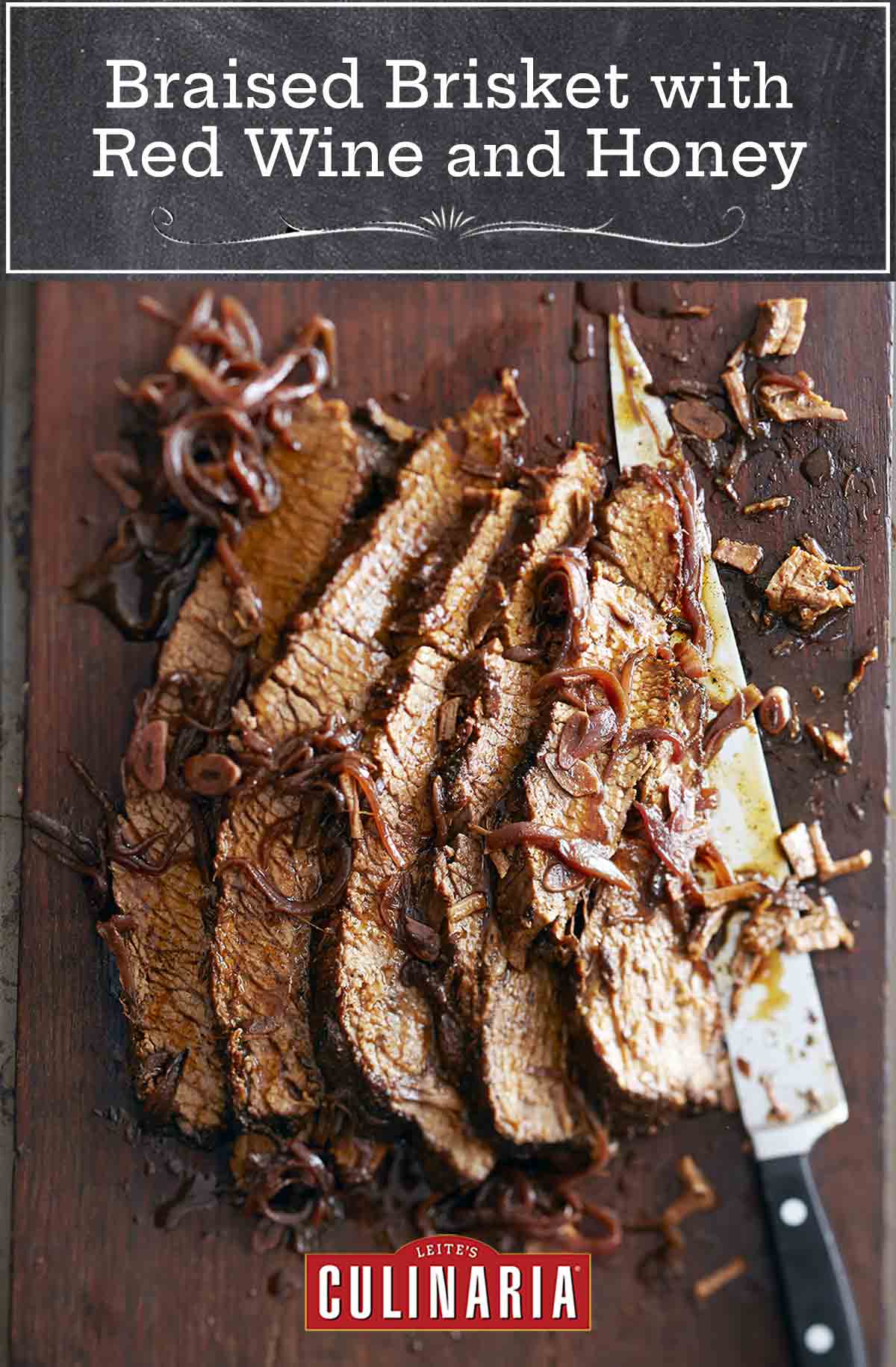 A sliced piece of braised brisket with red wine and honey laying on a cutting board with a large knife and covered with braised onions.