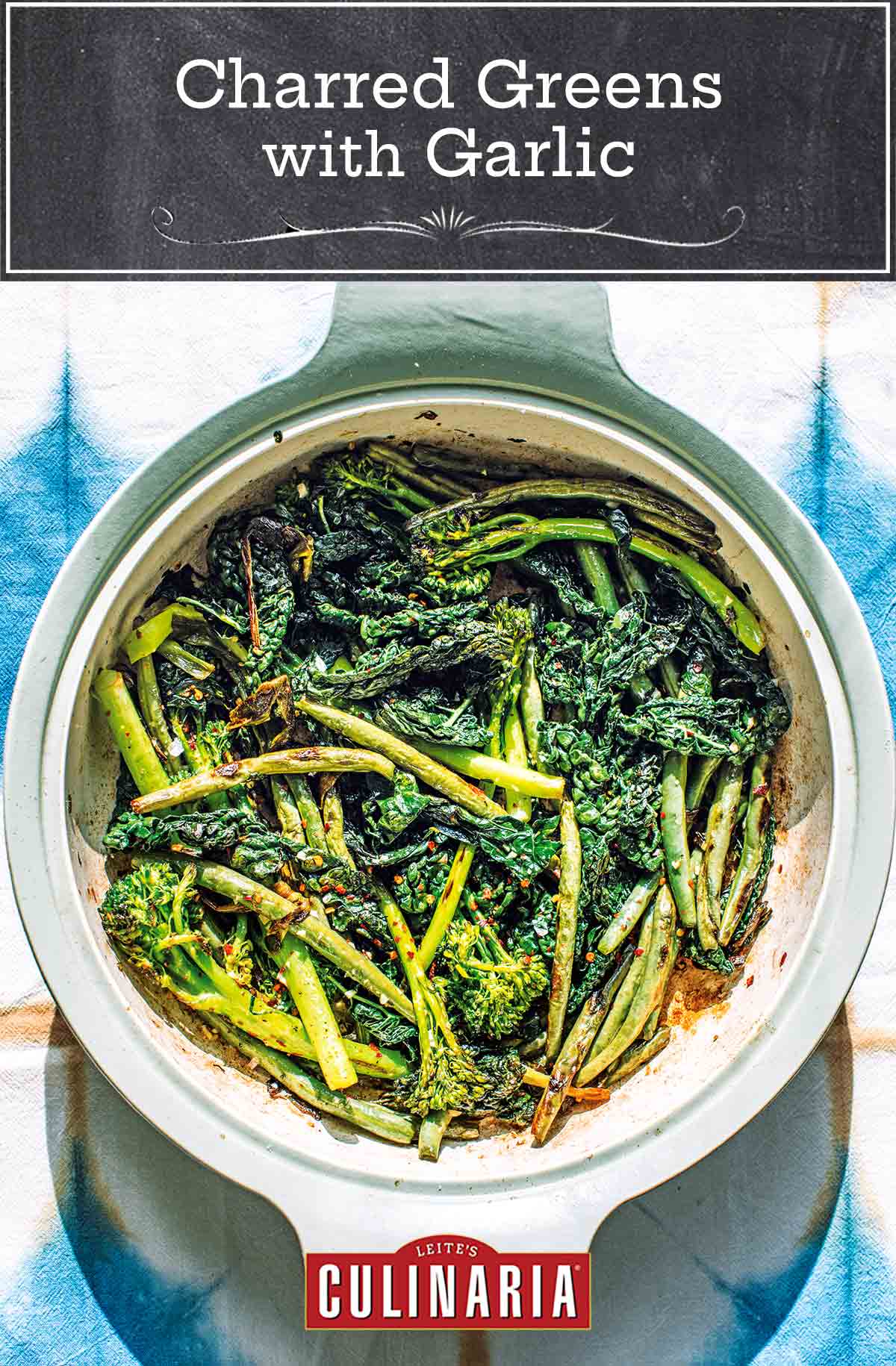 A soft green casserole dish filed with lightly charred broccolini, kale, and green beans, sprinkled with chile flakes and garlic.