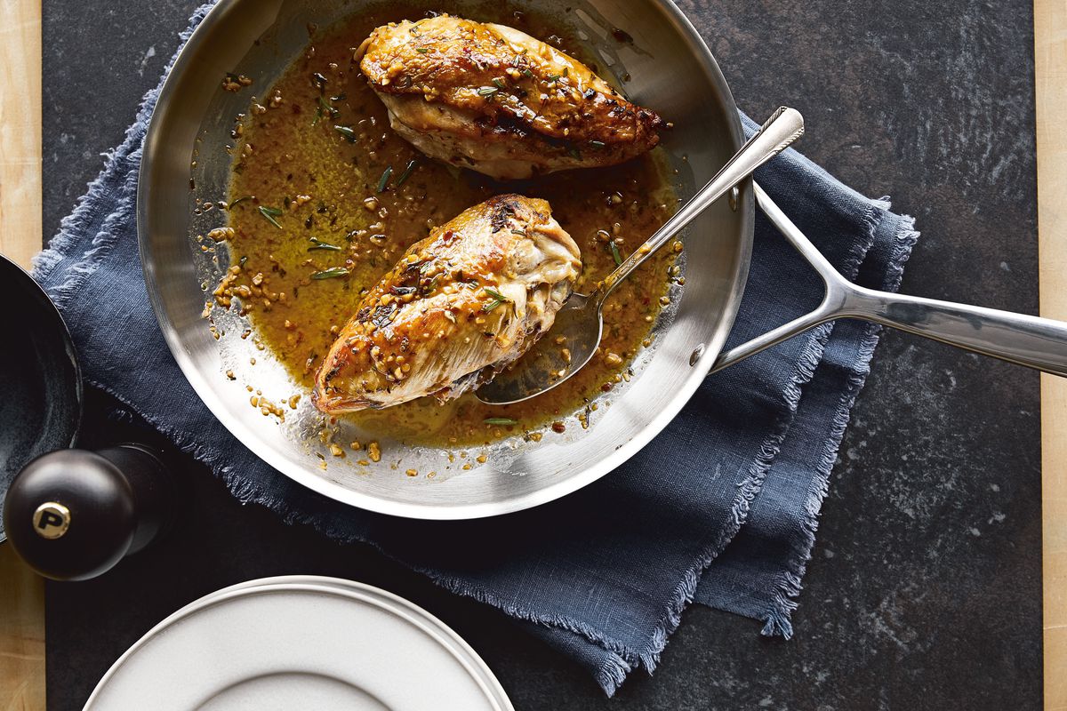 A skillet with Chrissy Teigen’s crispy-skinned chicken with lemon-rosemary pan sauce.
