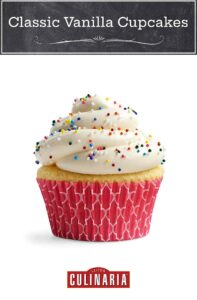 A classic vanilla cupcake with cream cheese frosting with rainbow sprinkles, in a pink cupcake paper.
