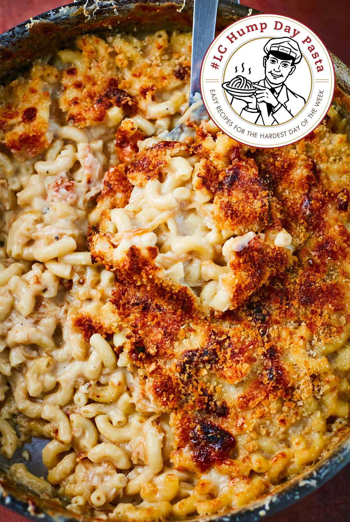 A large pot filled with French onion mac and cheese, with a few servings missing and a large serving spoon.