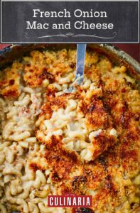 A large pot filled with French onion mac and cheese, with a few servings missing and a large serving spoon.