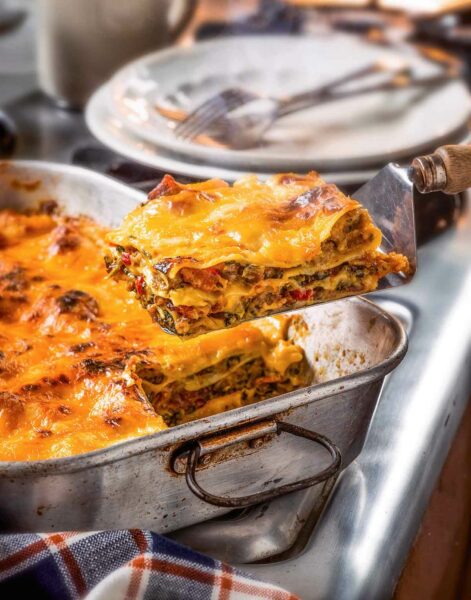 Garth Brooks' favorite breakfast lasagna in a metal lasagna pan, with one square on a metal spatula.