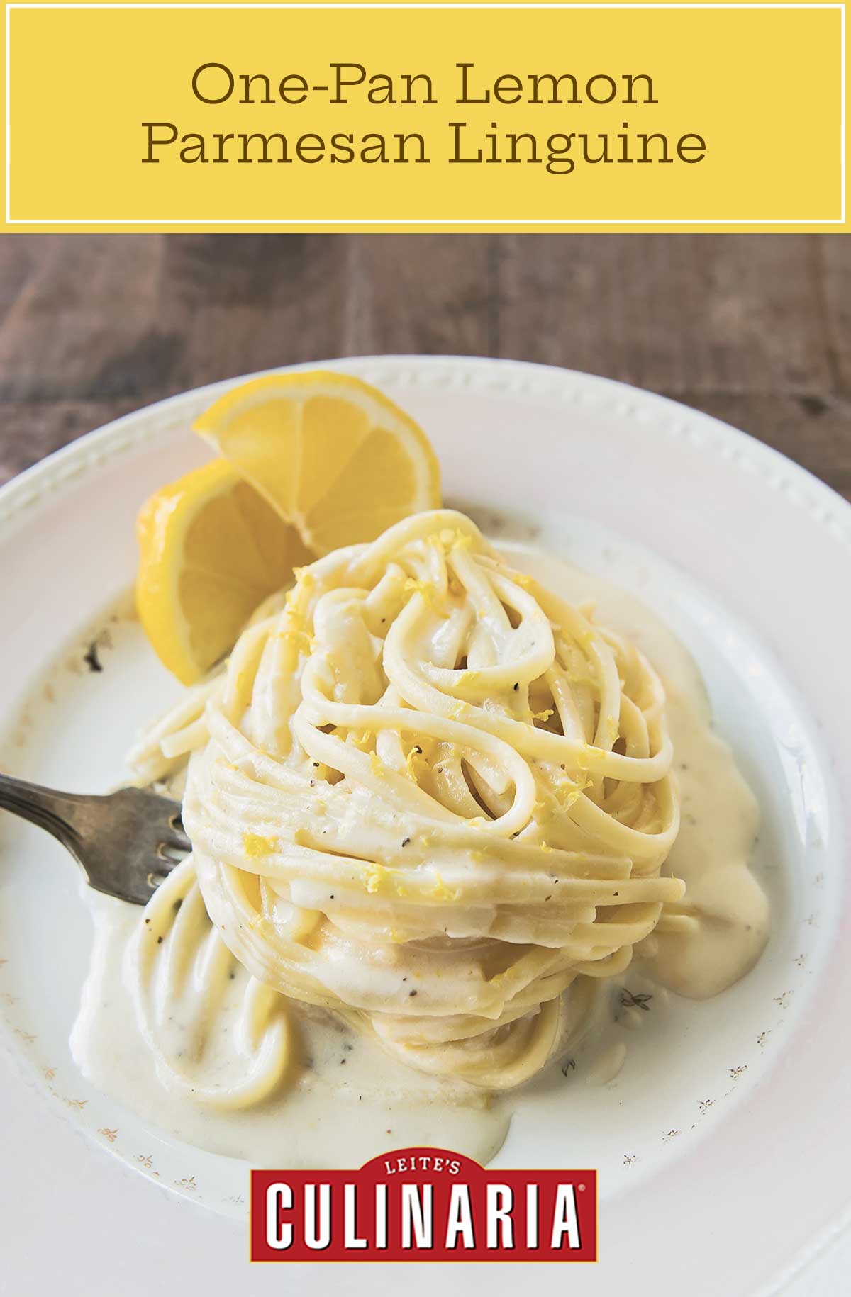 A white plate with a swirl of One-Pan Lemon Parmesan Linguine, with creamy sauce, a fork and 2 slices of lemon.