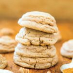 Pumpkin spice cookies stacked on a wooden cutting board.