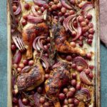 Sheet pan chicken with rosemary and grapes on a large metal pan with a fork, on a linen napkin.