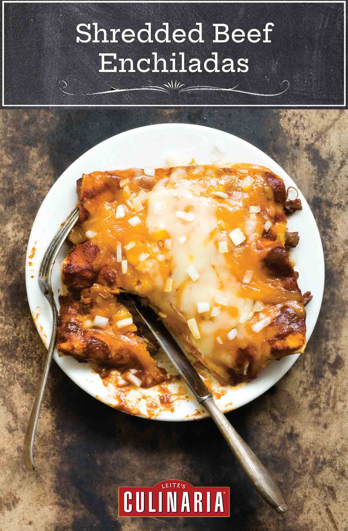 A white plate with 3 shredded beef enchiladas covered with melted cheese and diced onions, with a knife and fork.