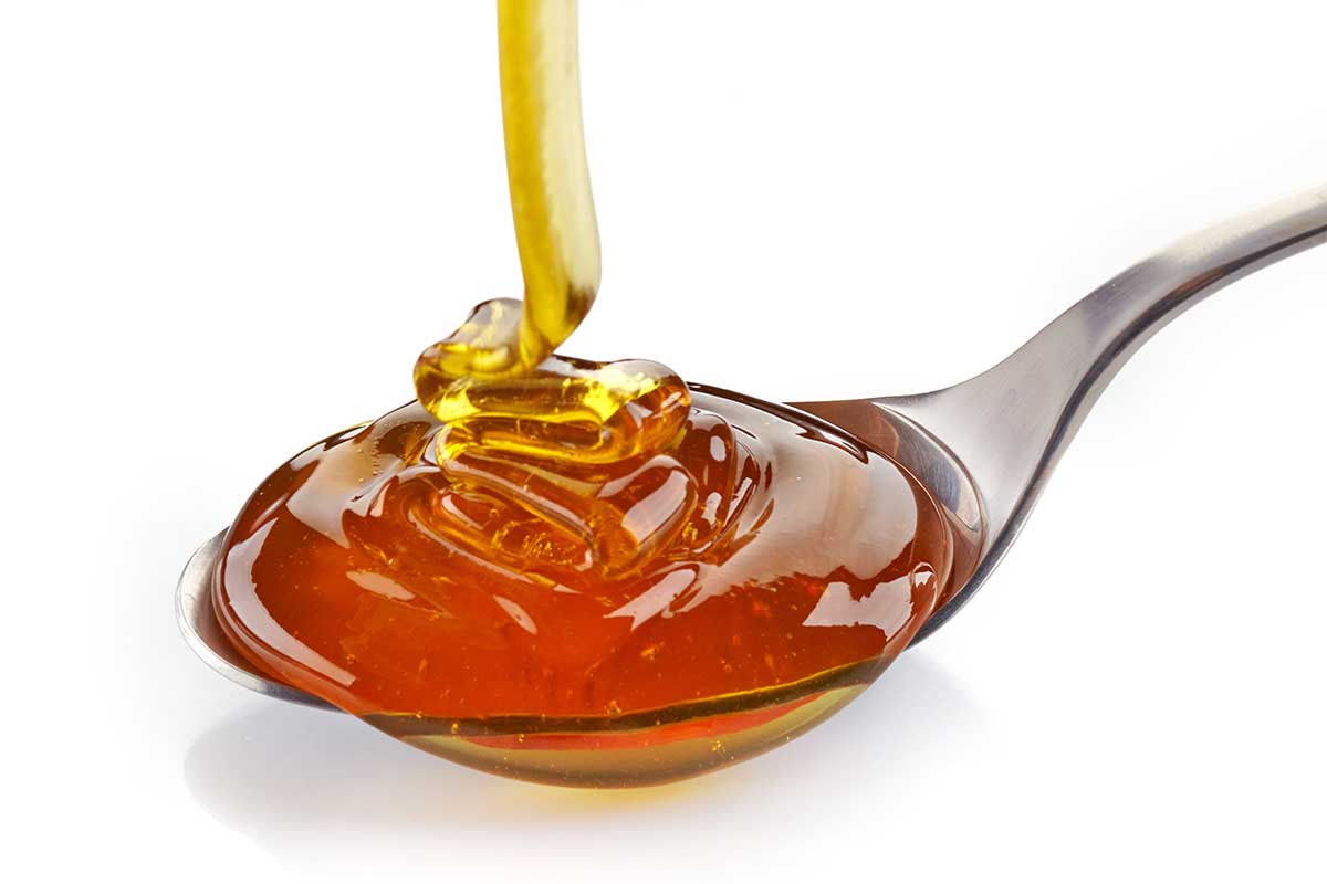 Honey being drizzled onto a spoon.