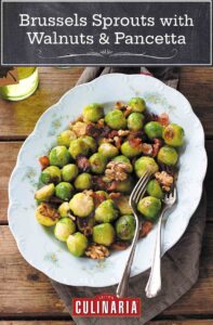 Brussels Sprouts with Walnuts and Pancetta on a large white floral platter with 2 serving forks.