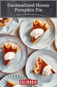 Caramelized honey pumpkin pie in slices on dessert plates, each garnished with dollops of whipped cream and pumpkin pie spice.