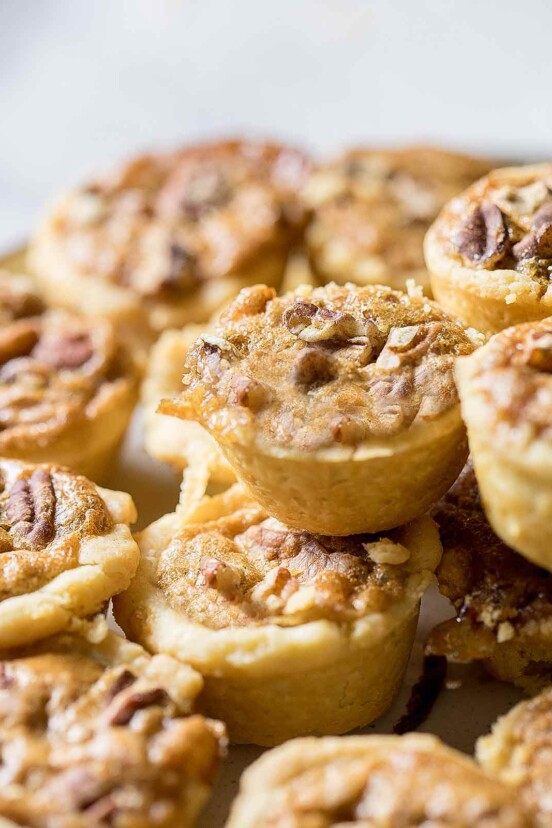 Pecan tassies in close-up, piled on top of each other.