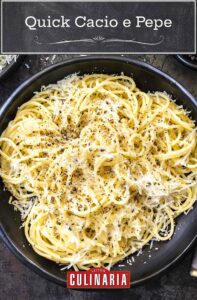 Quick cacio e pepe in a large black serving bowl beside a bowl of shredded cheese and a bowl of black pepper.