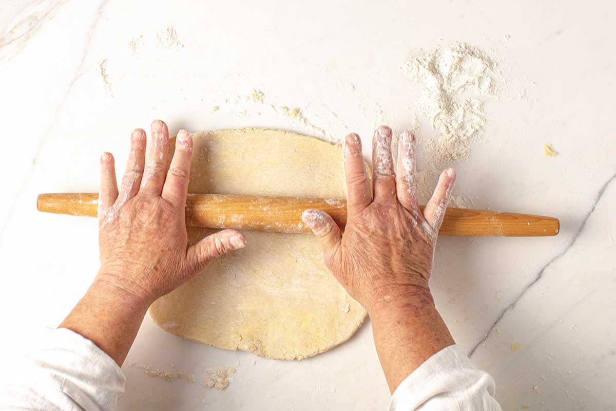 A person rolling out a pie crust