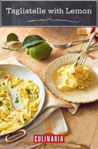 Tagliatelle with lemon on a large serving pate beside a smaller plate with noodles being twirled on a fork. Next to it, there are more forks and some lemons and a chunk of Parmesan.