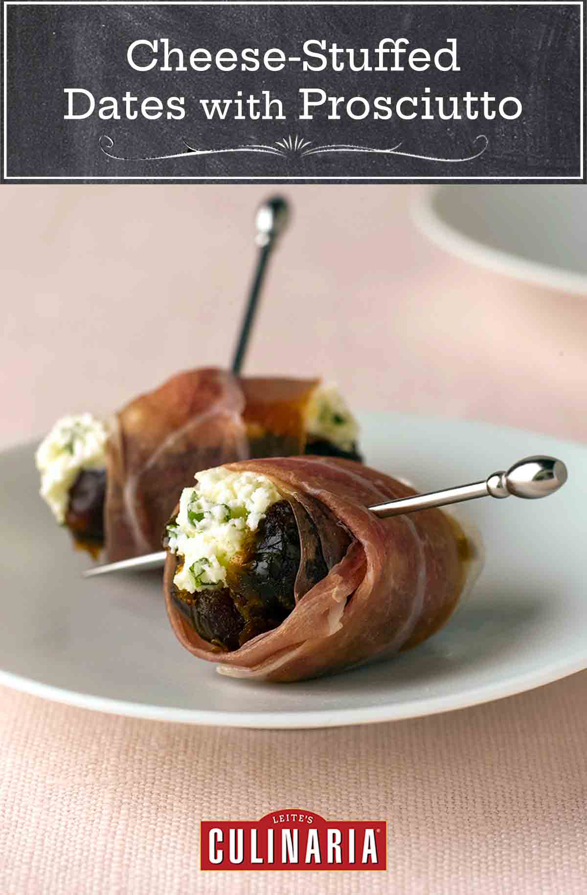 Two cheese-stuffed dates with Proscuitto on a white plate with metal pins securing them.