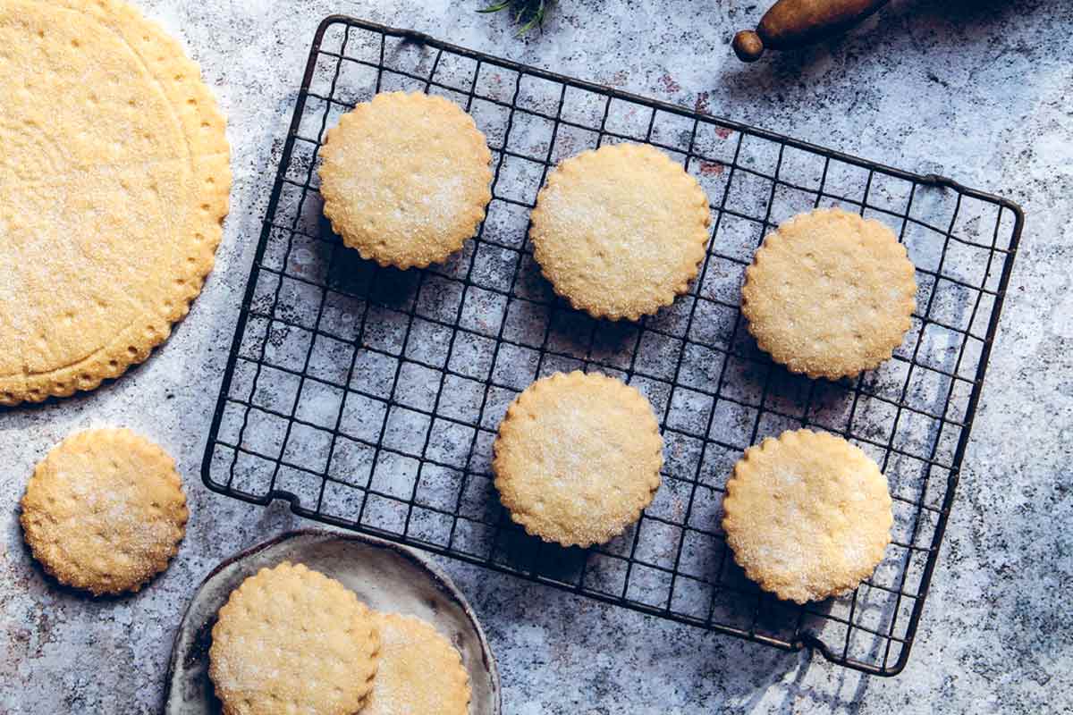 Easy shortbread cookies cooling on a wire rack, beside a rolling pin and a large shortbread petticoat.