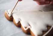 A tree-shaped cookie being filled with royal icing.
