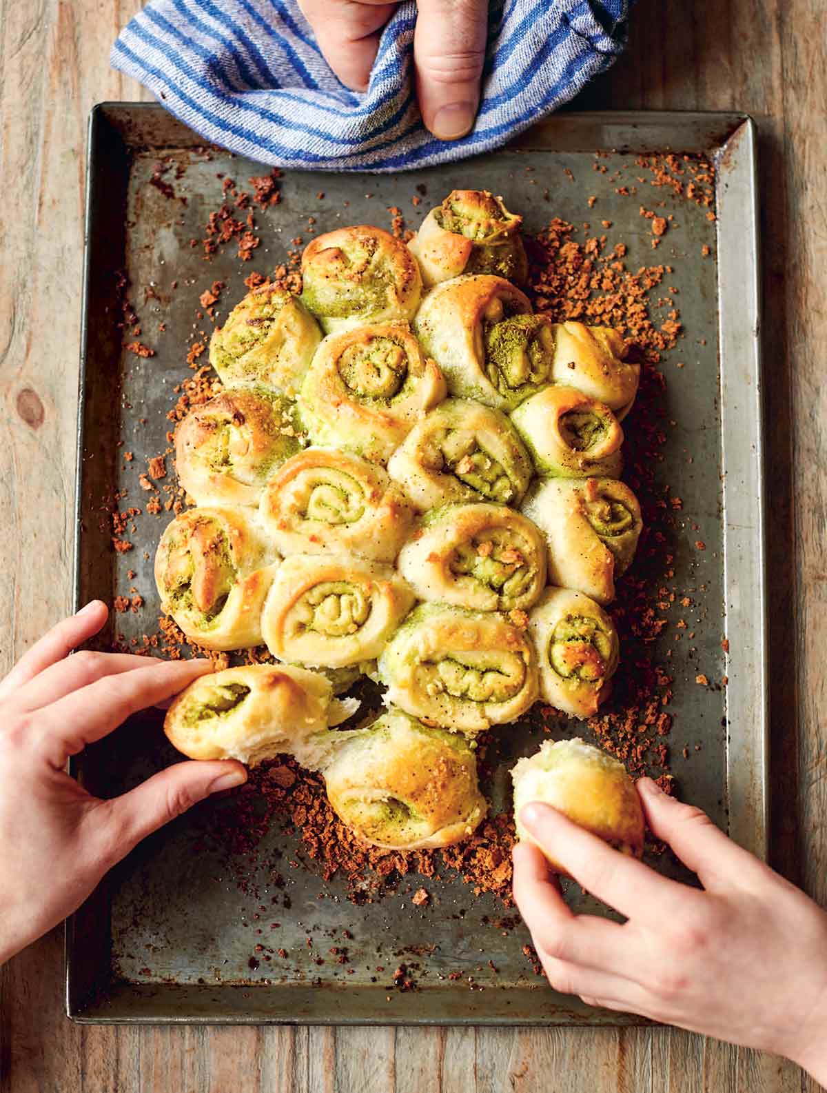 Jamie Oliver's Garlic Pull-Apart Rolls på en plåtplåt, garnerad med krispiga brödsmulor och dras isär med två händer.