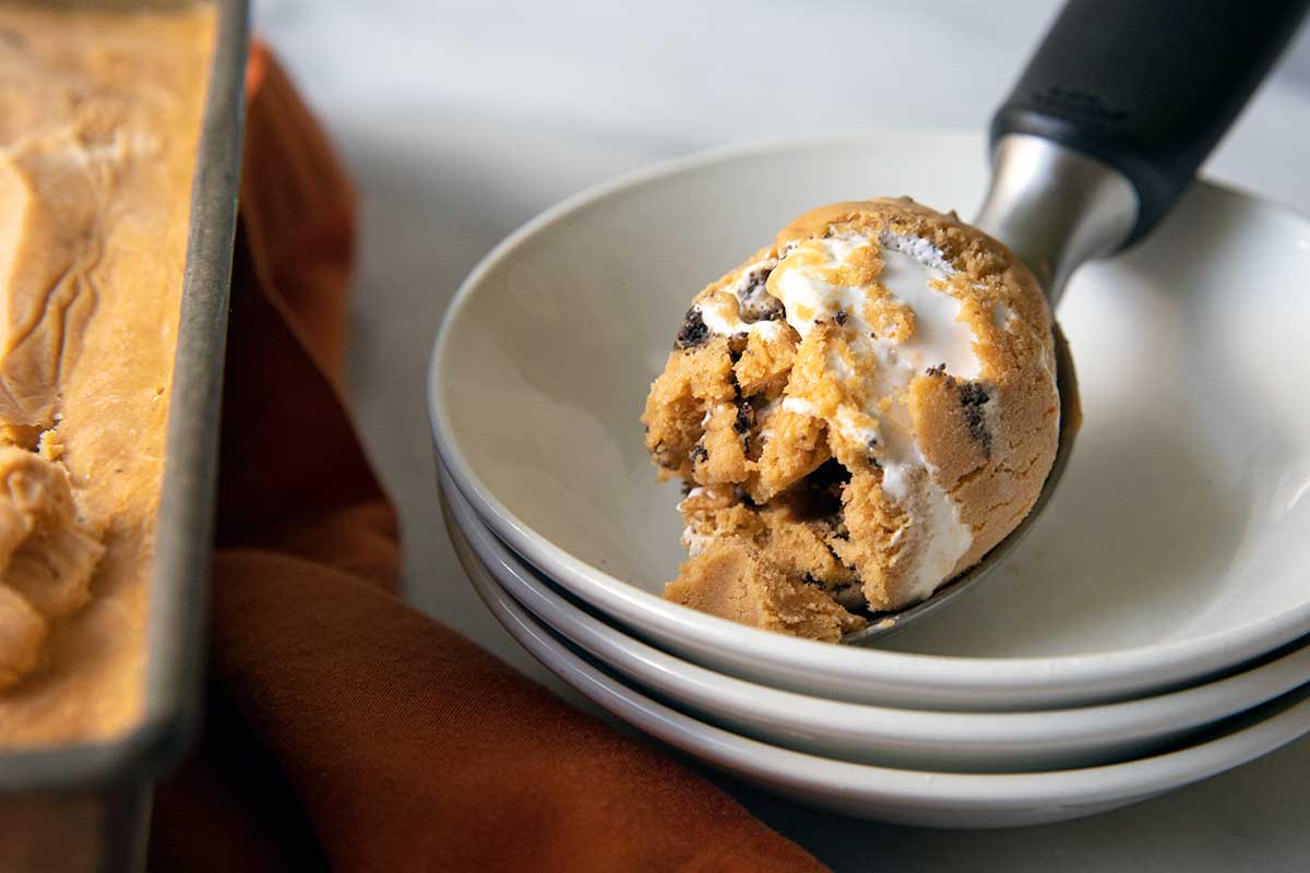 A stack of bowls of Pumpkin Meringue Pie Ice Cream with a scoop