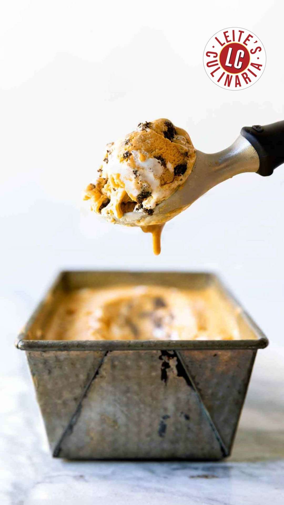 A container of Pumpkin Meringue Pie Ice Cream with a scoop.