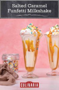 Salted caramel funfetti milkshakes in tall parfait glasses with sprinkles, beside a jar of sprinkles and a linen napkin.