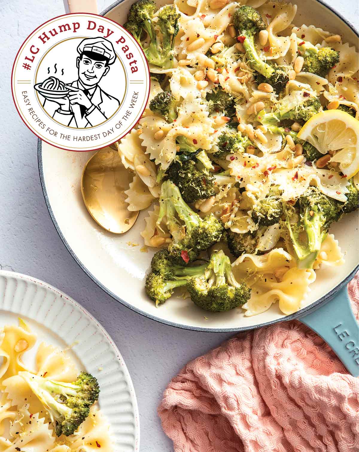 Vegan lemon broccoli bow ties in a white enamel pan with a spoon and sliced lemons, beside a white plate full of pasta.