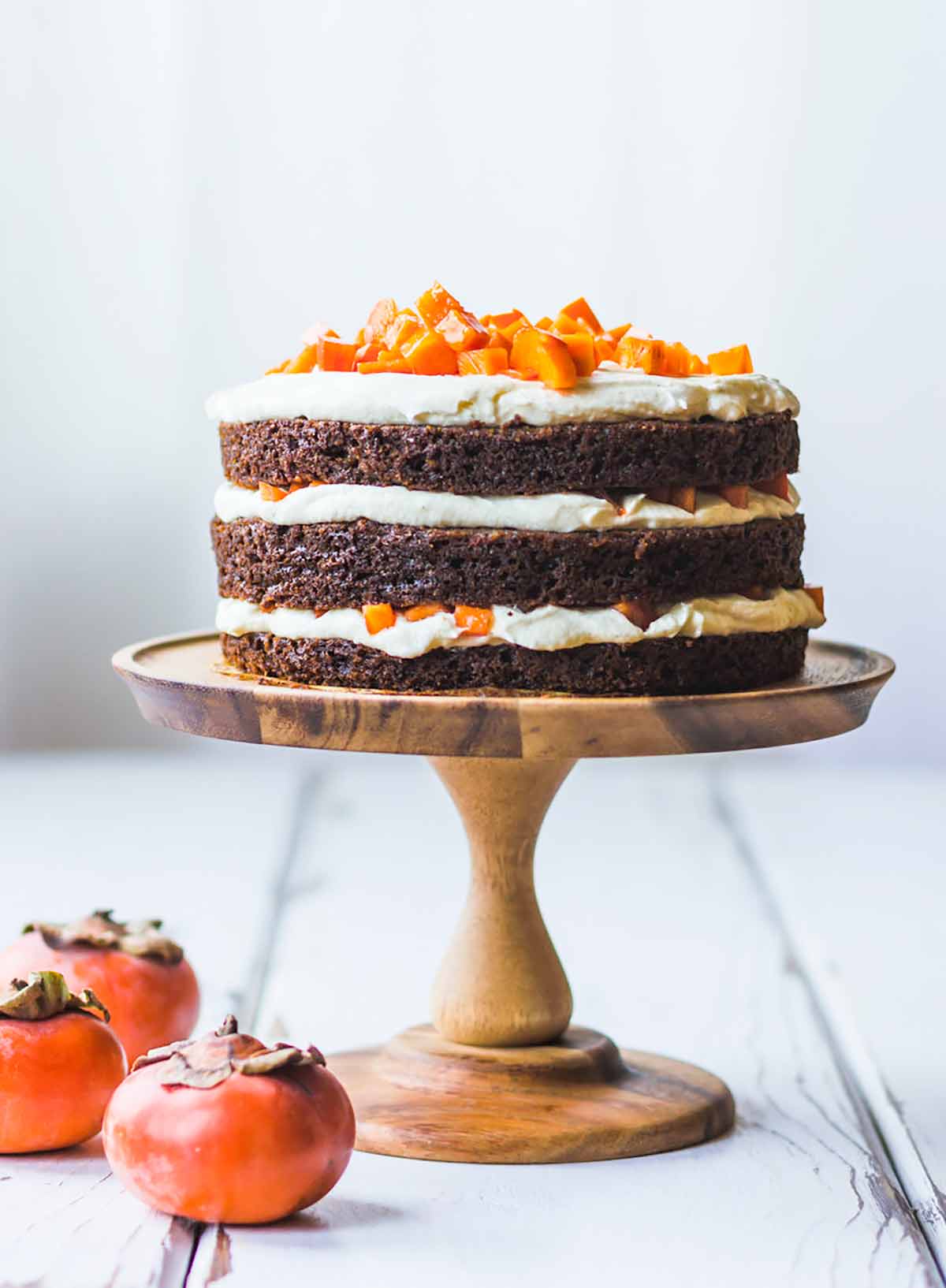 A triple-layer cake with white filling and chopped persimmons on top an example of high altitude baking
