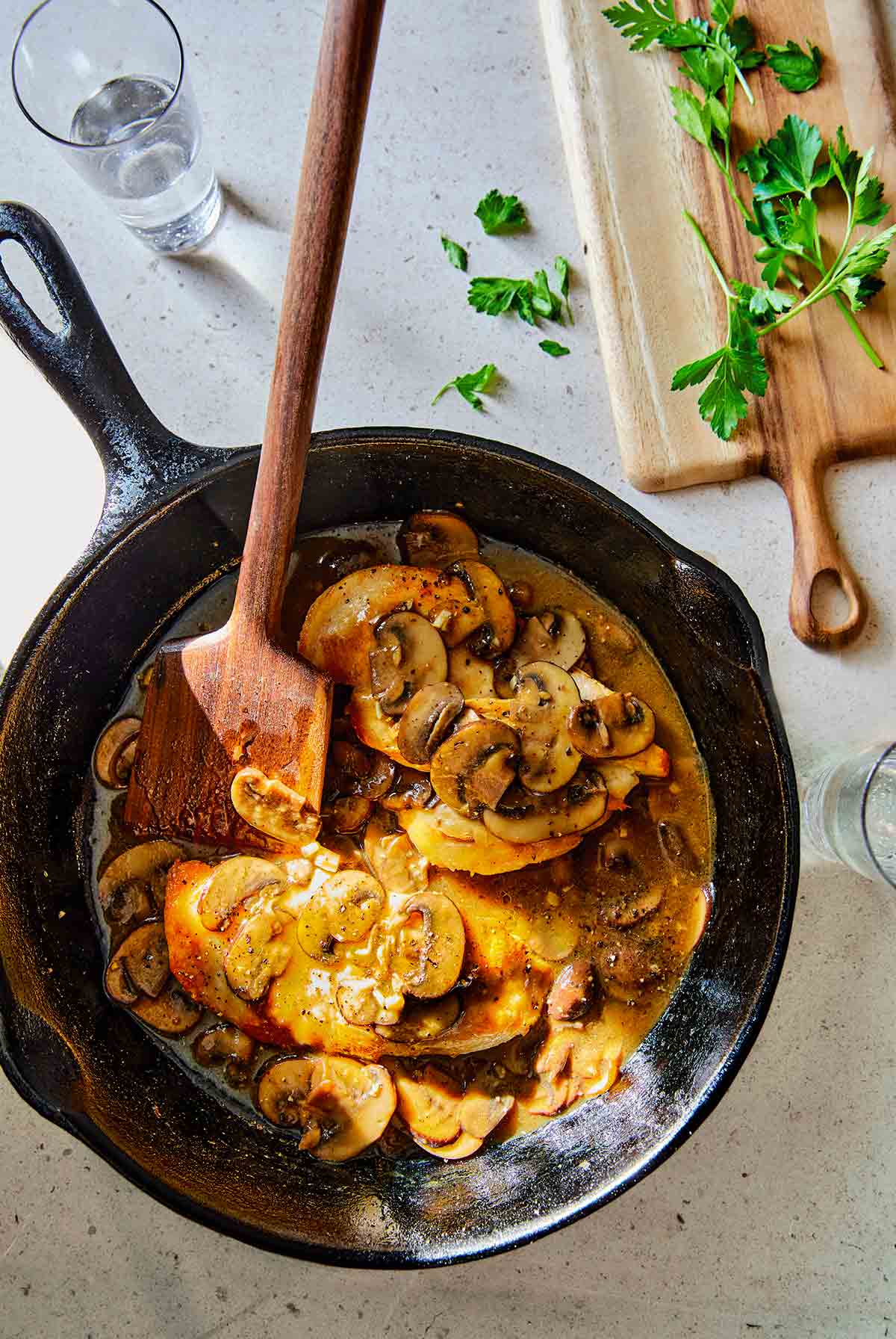 A cast-iron skillet with low-carb chicken Marsala on a counter