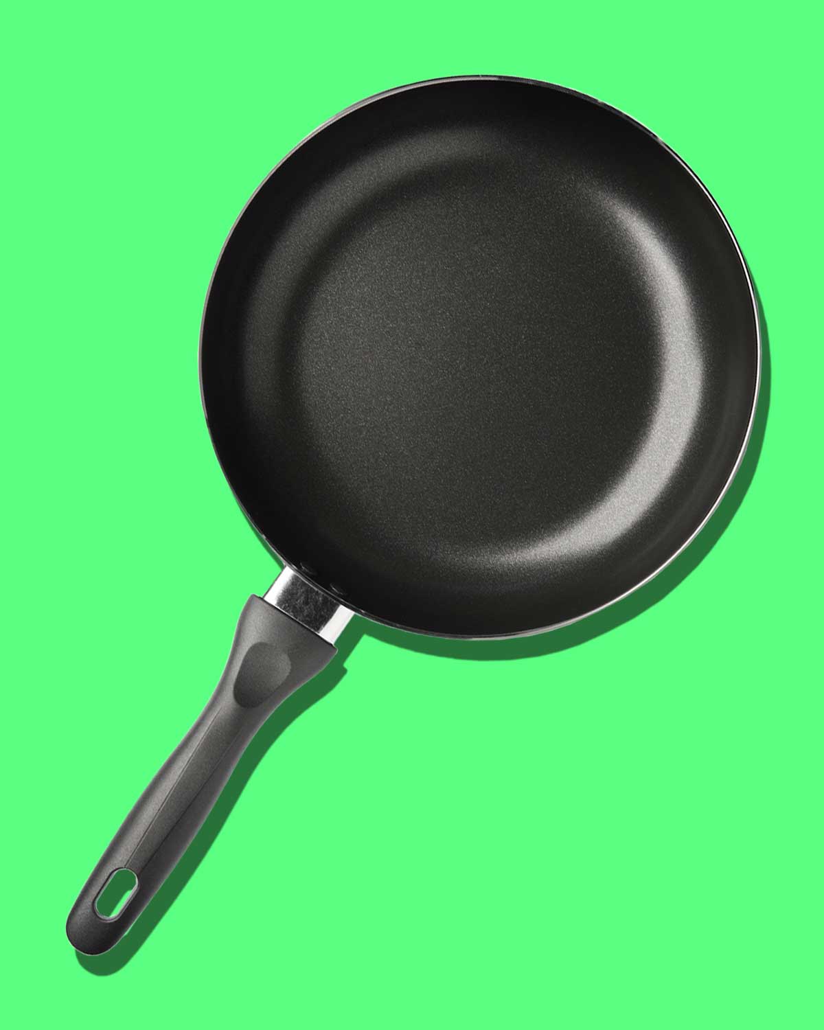 A nonstick skillet in response to the question 'is it safe to cook in a nonstick skillet?' on a green background