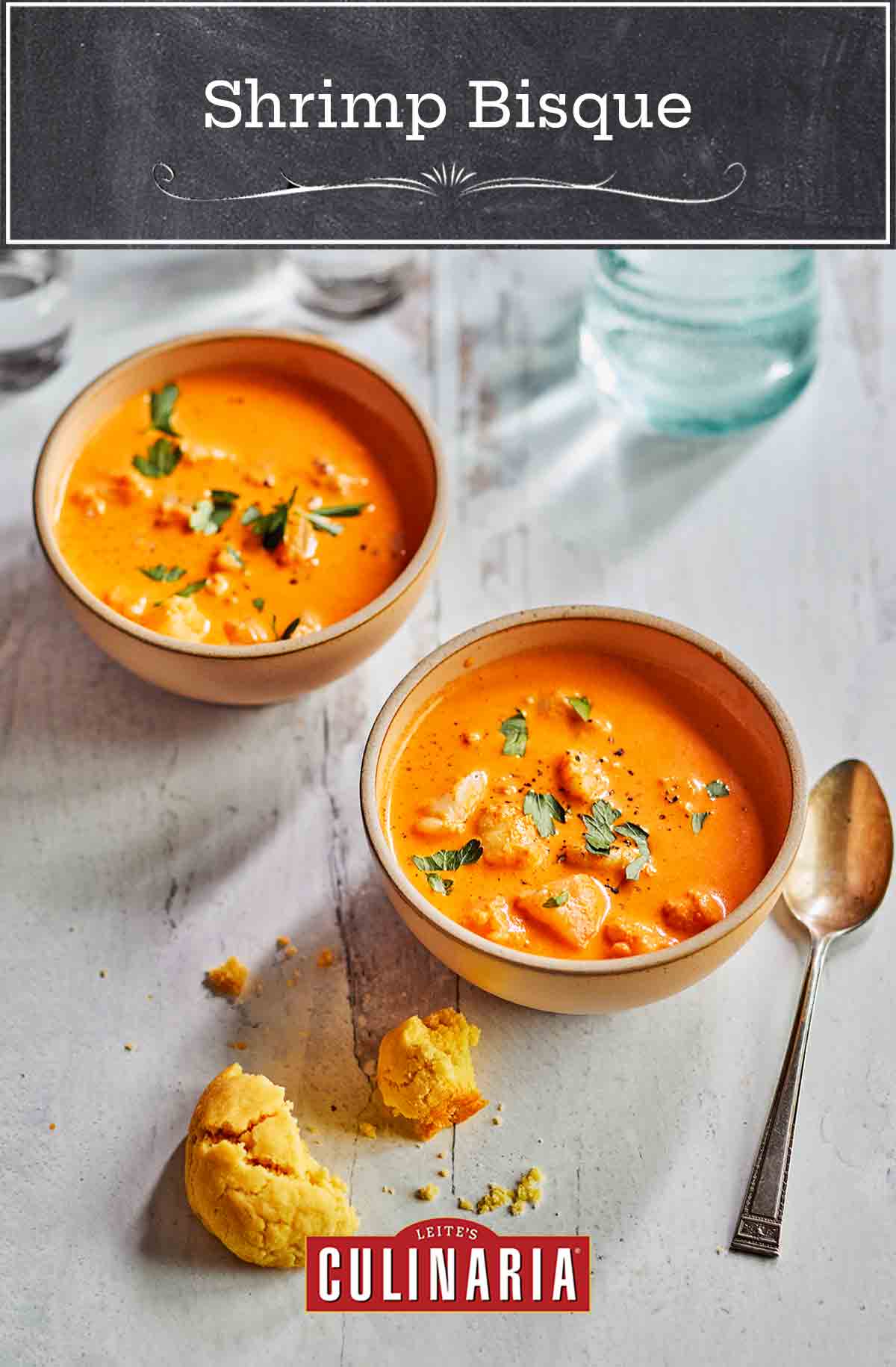 Two bowls of shrimp bisque on a white table
