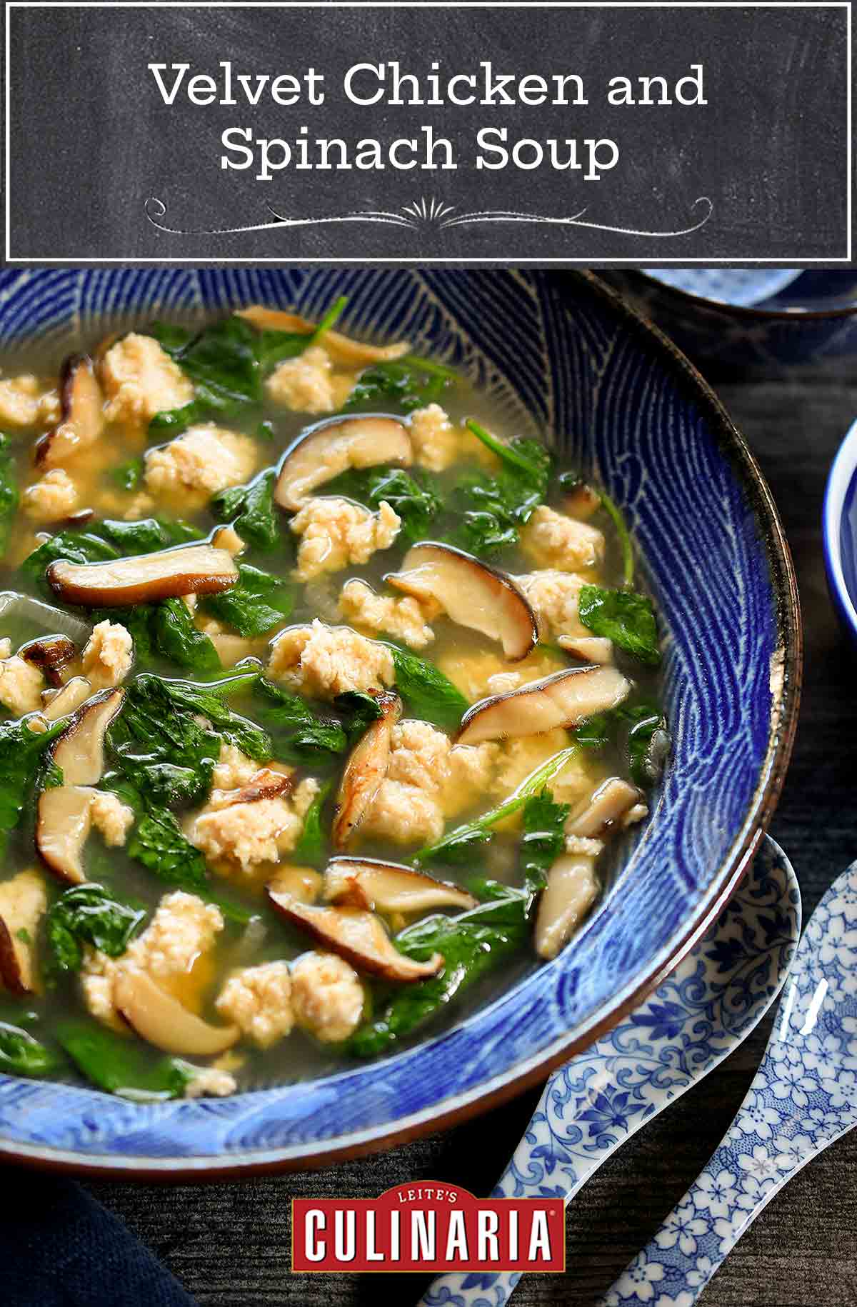 A blue and white bowl filled with velvet chicken and spinach soup