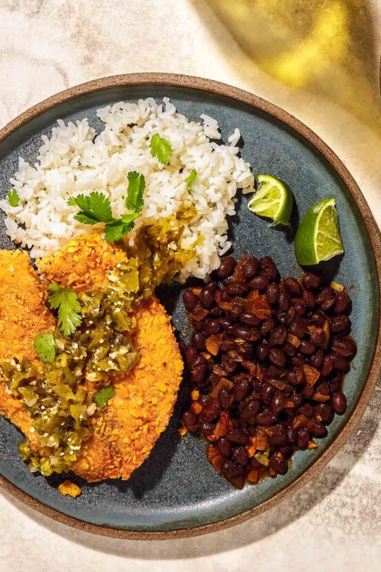 Air fryer tilapia with tortilla crust on a plate with rice and beans