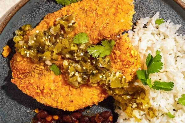 Air fryer tilapia with tortilla crust on a plate with rice and beans