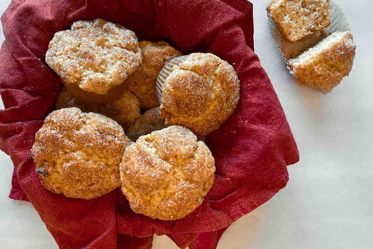A basket of apple cinnamon muffins lined with a red napkin