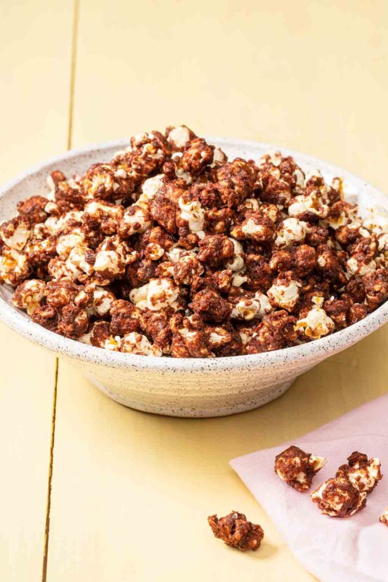 A bowl of chocolate-covered popcorn on a yellow background