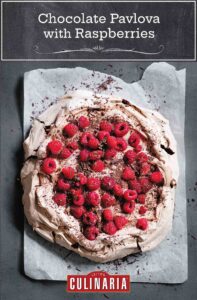 A chocolate pavlova with raspberries on parchment paper