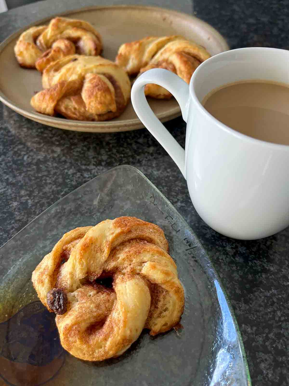 A plate with east cinnamon knots and a cup of coffee