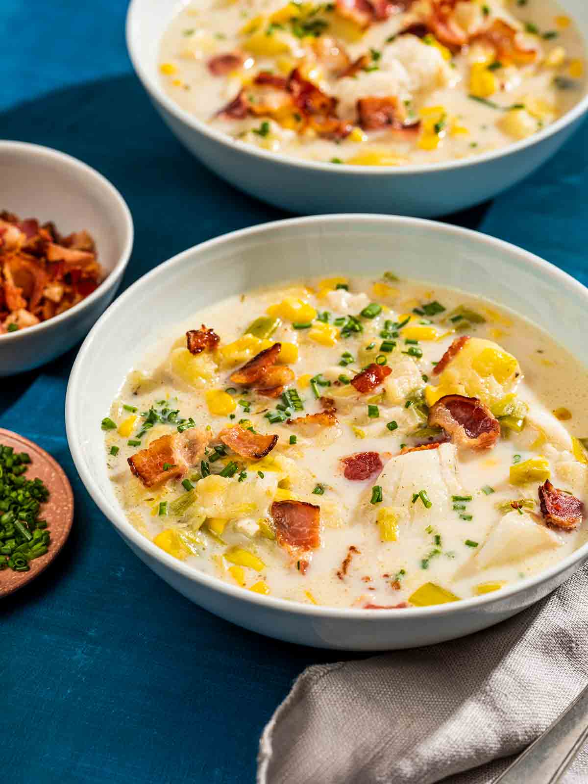 Two bowls of Instant Pot New England fish chowder on a blue background