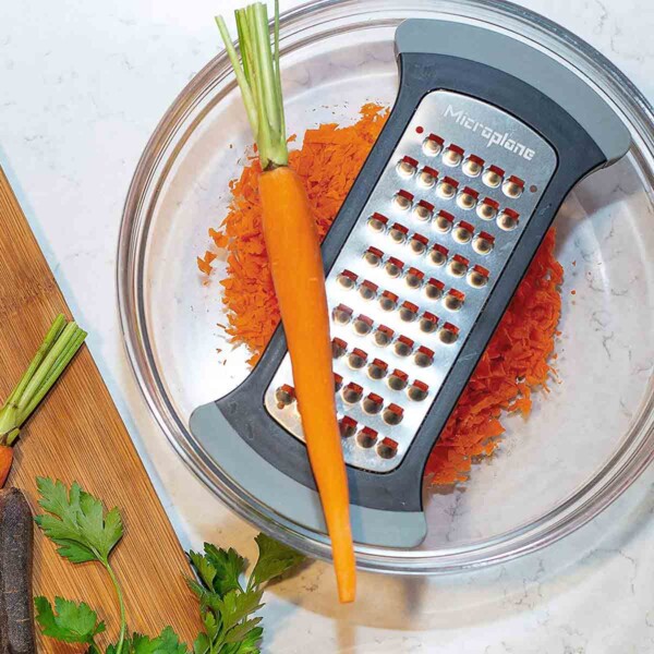 Microplane Mixing Bowl Grater top view of glass bowl with peeled carrot on top.