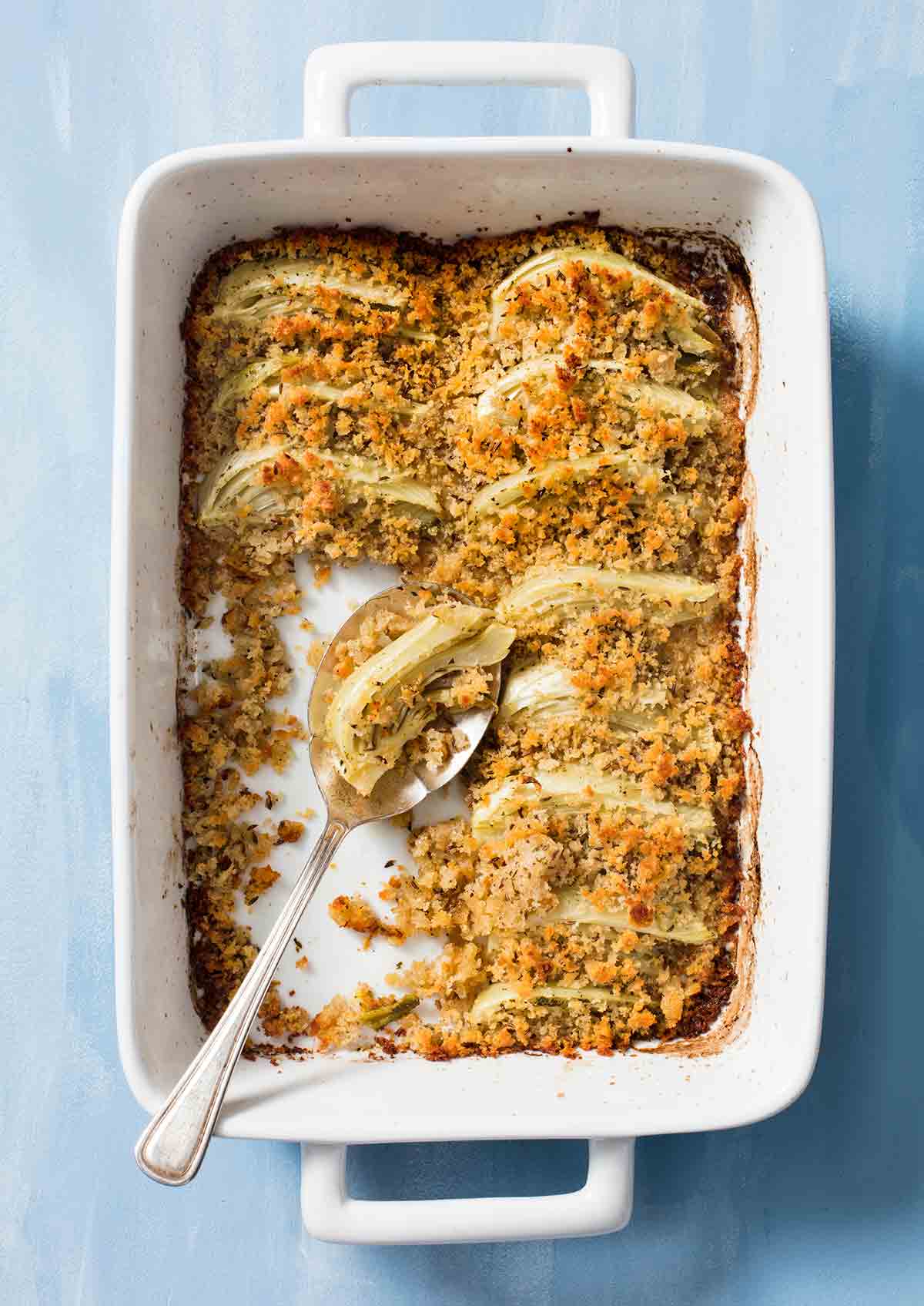 a white casserole dish of roasted fennel with rye crumble