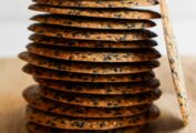 A stack of sesame crisps on a cutting board