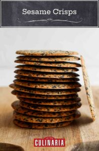 A stack of sesame crisps on a cutting board