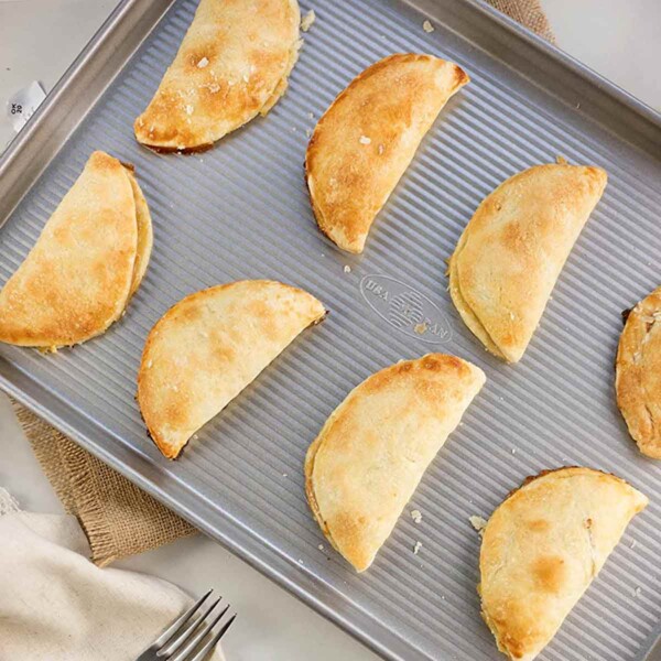 USA Bakeware Half Sheet Pan Set with empanadas.