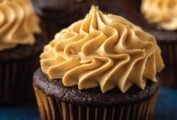 Several chocolate cupcakes with peanut butter buttercream frosting piped on top.