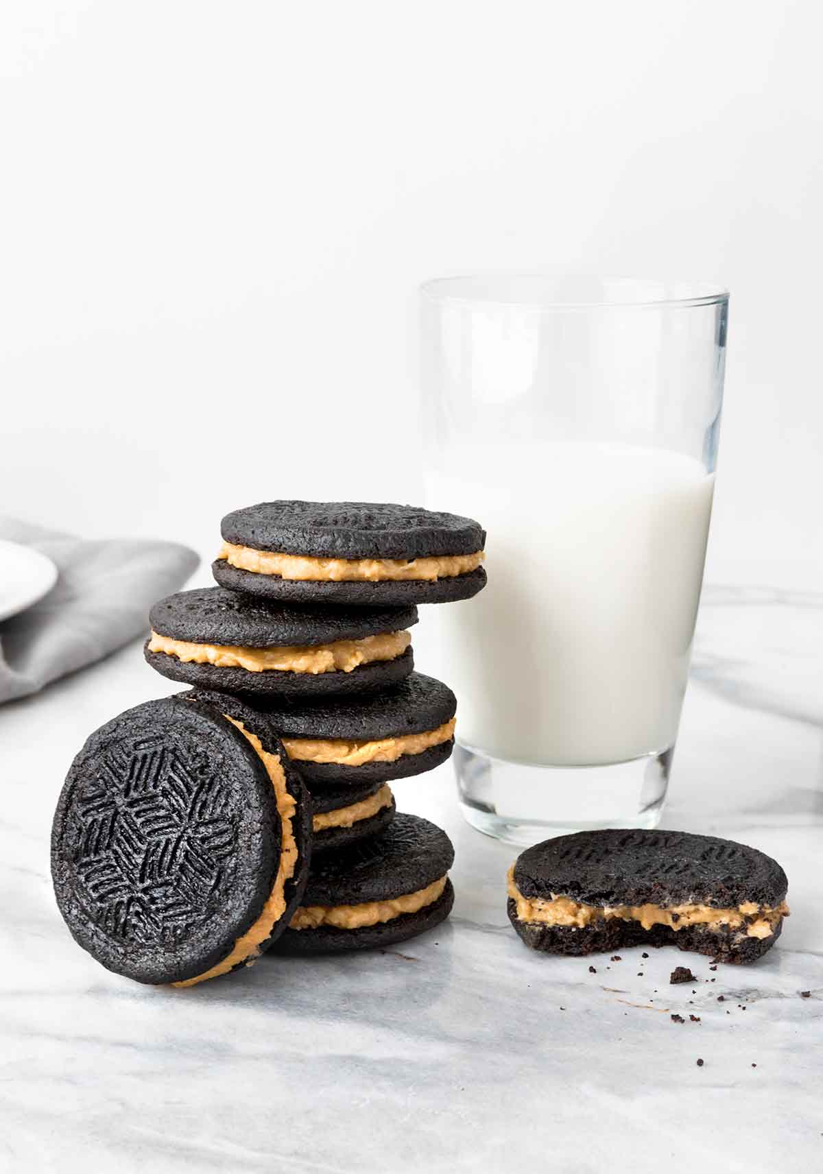 A pile of homemade caramel-coconut oreos and a glass of milk