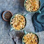 Three individual bowls of Instant Pot tuna noodle casserole with three forks and a blue kitchen towel on the side.