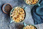 Three individual bowls of Instant Pot tuna noodle casserole with three forks and a blue kitchen towel on the side.