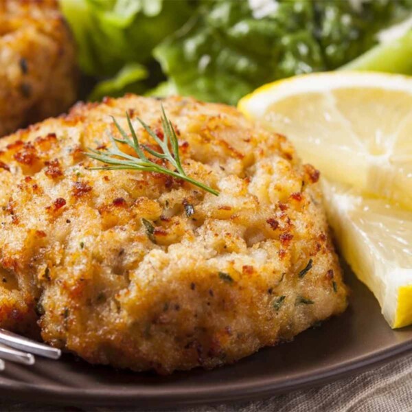 Rastelli's Crab Cakes on plate with dill and lemon.