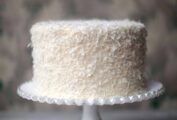 A Brown Betty Bakery coconut cake on a decorative white cake stand.